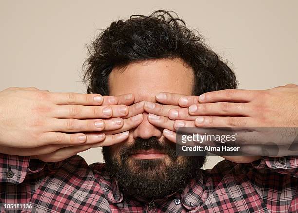 hairy man with lots of fingers over his eyes - mani sugli occhi foto e immagini stock