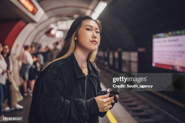 frau warten auf u-bahn - abwarten stock-fotos und bilder