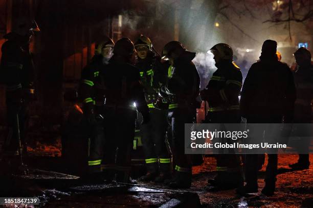 Rescuers respond at the site of a missile explosion in the yard of a high-rise residential building in Dniprovskyi district on December 13, 2023 in...