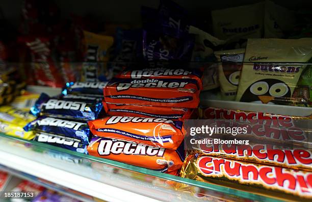 Cadbury Boost, Double Decker and Crunchie chocolate confectionary bars, manufactured by Kraft Foods Inc., sit displayed for sale in a newsagent's...