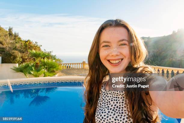 a young girl (circa 12 years old) takes a selfie whilst on a winter sun vacation in the costa blanca region of spain - 12 13 years old girls imagens e fotografias de stock