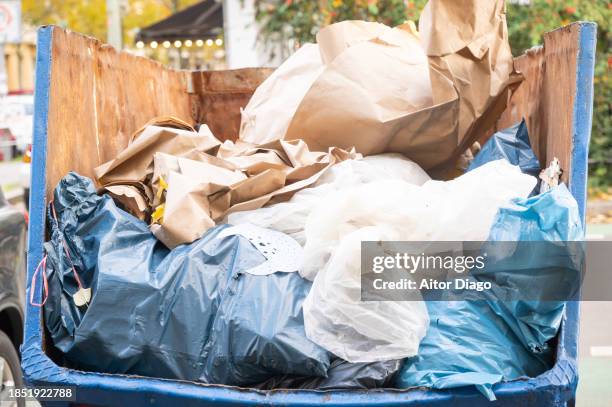 nearly full container on the street - müllcontainer stock-fotos und bilder