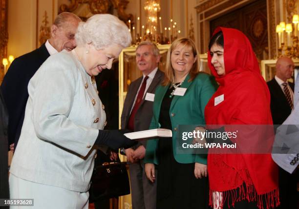 Malala Yousafzai presents a copy of her book to Queen Elizabeth II and Prince Philip, Duke of Edinburgh during a Reception for Youth, Education and...