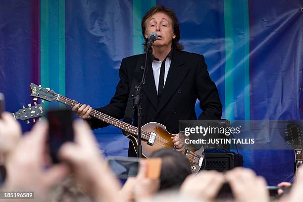 British musician Paul McCartney performs during an impromptu gig in Covent Garden in London on October 18, 2013. Paul McCartney played a surprise gig...