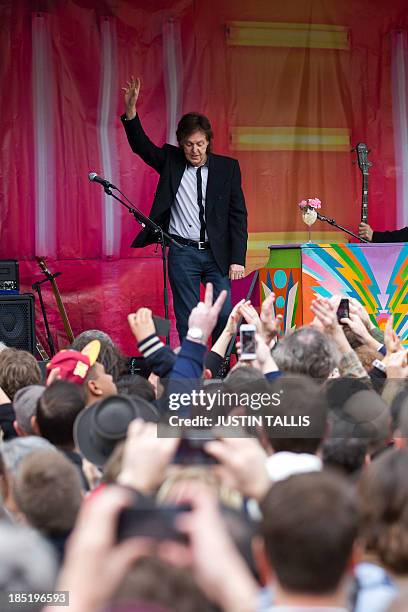 British musician Paul McCartney waves to the crowd following an impromptu gig in Covent Garden in London on October 18, 2013. Paul McCartney played a...