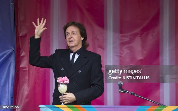 British musician Paul McCartney waves to the crowd following an impromptu gig in Covent Garden in London on October 18, 2013. Paul McCartney played a...