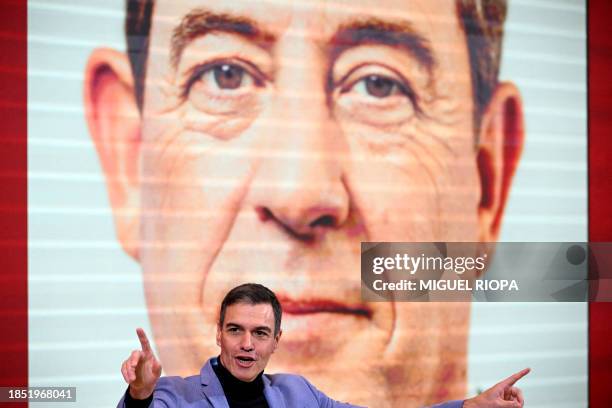 Spanish Prime Minister and Socialist Party leader Pedro Sanchez delivers a speech as an image of the socialist candidate for the Galician regional...