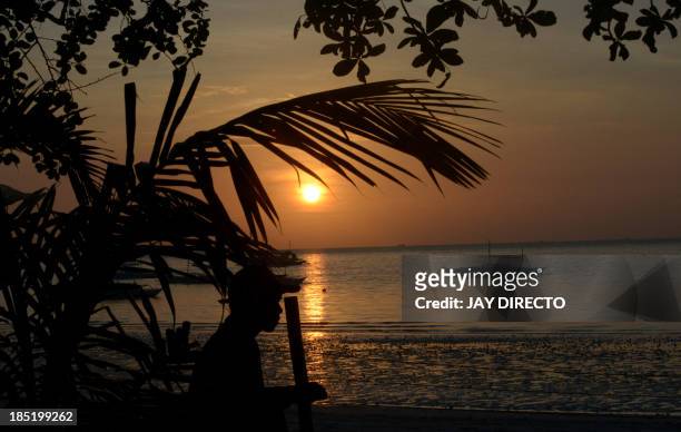 The sun rises over boats in Panglao island in Bohol on October 18 the area where a 7.1 magnitude quake struck on October 15. The death toll from a...