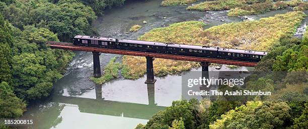 In this aerial image, JR Kyushu's luxury sleeper train 'Nanatsuboshi ' crosses an iron bridge on October 15, 2013 in Hita, Oita, Japan. When shared...