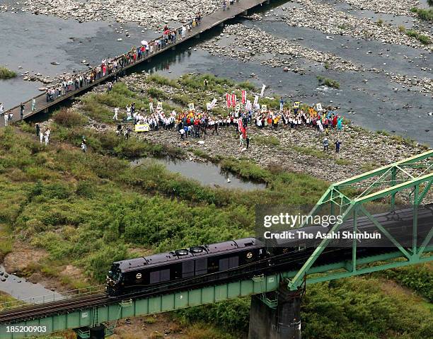 In this aerial image, people wave toward JR Kyushu's luxury sleeper train 'Nanatsuboshi ' runs on October 15, 2013 in Fukuoka, Japan. When shared by...
