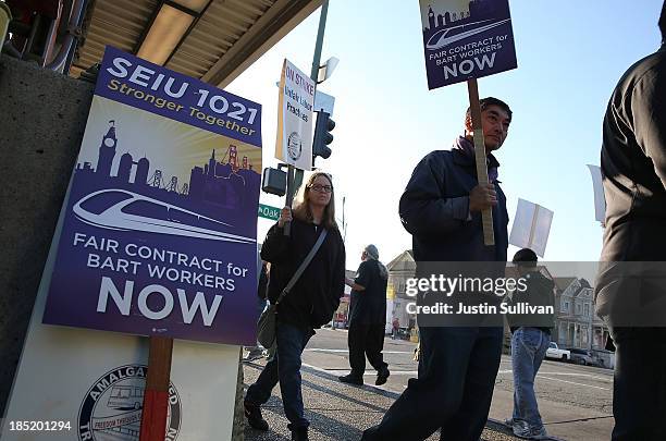 Bay Area Rapid Transit workers carry signs as they picket in front of the Lake Merritt BART station on the first day of the BART strike on October...
