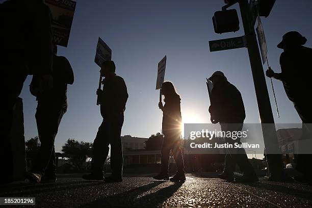 Bay Area Rapid Transit workers carry signs as they picket in front of the Lake Merritt BART station on the first day of the BART strike on October...