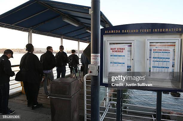 Commuters line up to board the San Francisco Bay Ferry on the first day of the Bay Area Rapid Transit strike on October 18, 2013 in Oakland,...