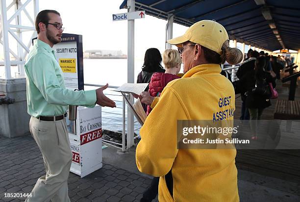 Gilda Tablizo passes out schedule information to commuters as they board the San Francisco Bay Ferry on the first day of the Bay Area Rapid Transit...
