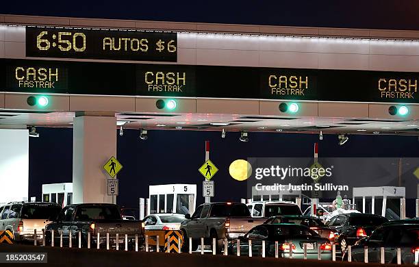 The moon sets as traffic backs up at the San Francisco-Oakland Bay Bridge toll plaza while commuters make their way into San Francisco on the first...
