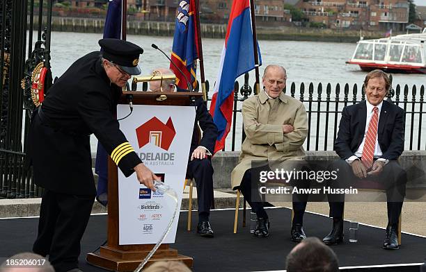 Prince Philip, Duke of Edinburgh and Bill Muirhead, Agent General of South Australia, laugh as Honorary Captain Andrew Chapman throws champagne to...