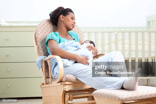 mother and baby are resting on rocking chair. - rocking chair stock pictures, royalty-free photos & images