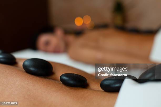 young couple enjoying lastone therapy - massage couple stock pictures, royalty-free photos & images