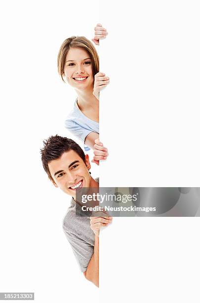 young adults looking around a corner - isolated - gluren stockfoto's en -beelden