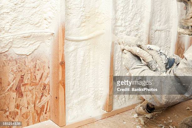 trabajador de la construcción de la pulverización, ampliables espuma aislamiento entre los tornillos de montaje en pared - latex fotografías e imágenes de stock