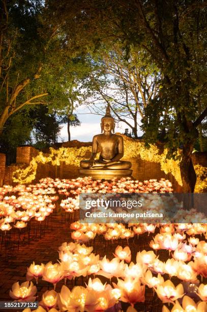 the beauty of sitting buddha statue with lighting decorated. abstract illuminated light festival background - thailand illumination festival ストックフォトと画像