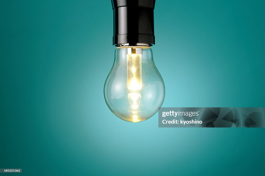 Illuminated LED light bulb against blue background with copy space