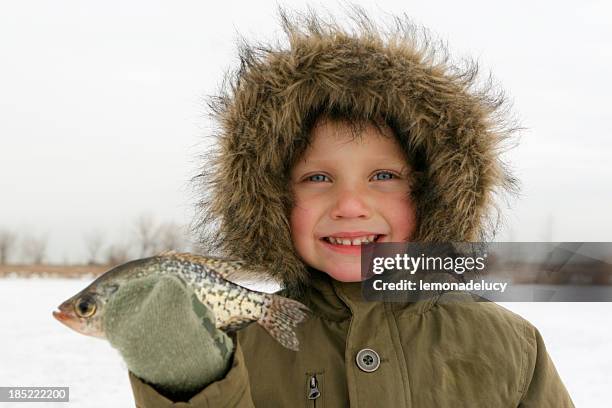 boy pesca sobre hielo tiene pescado - crappie fotografías e imágenes de stock