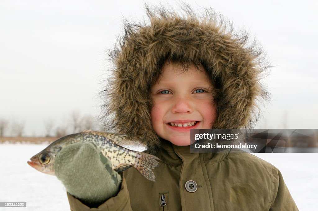 Boy Ice Fishing Holds Fish