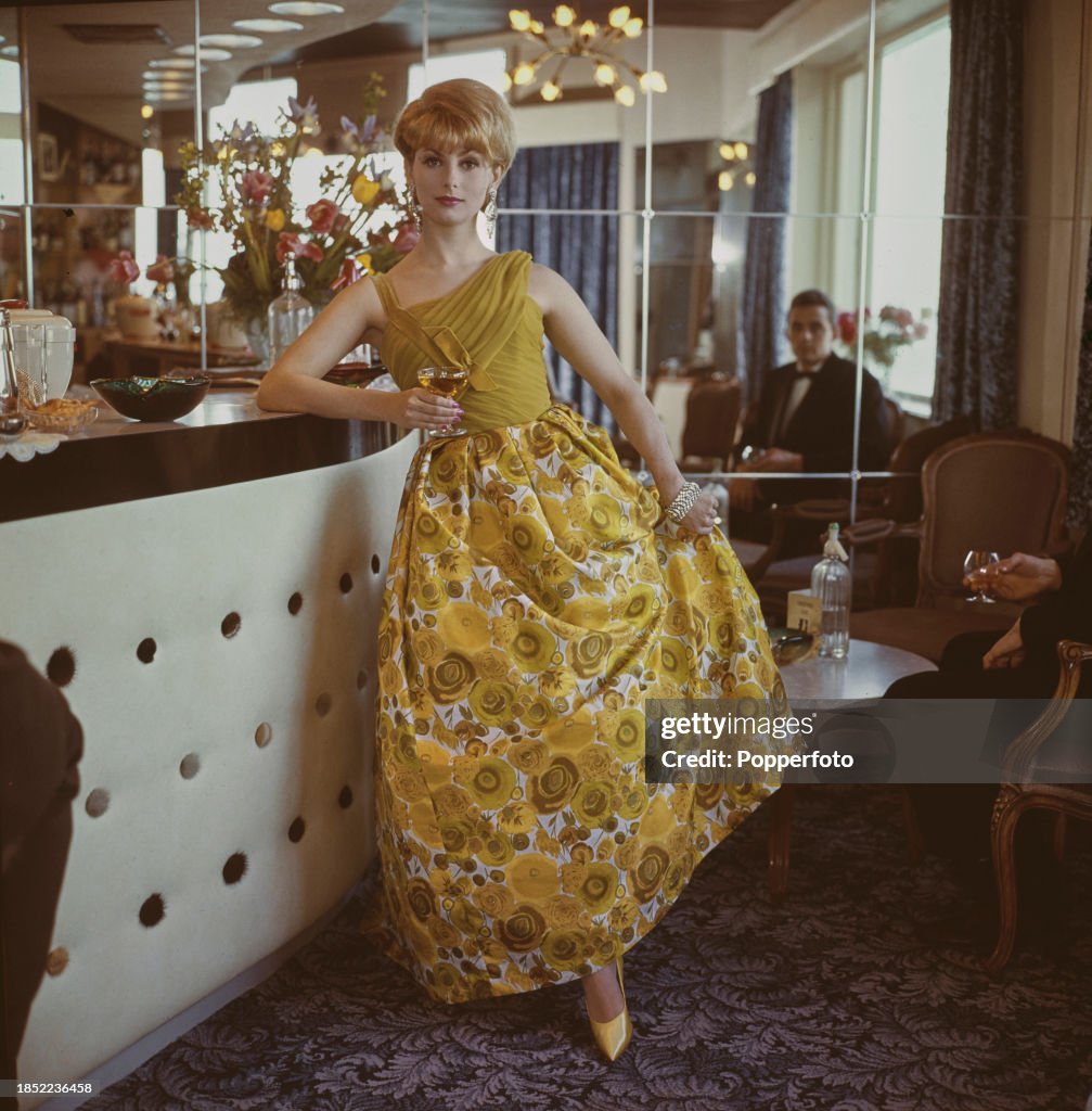 A female fashion model posed wearing a mustard yellow long evening ...