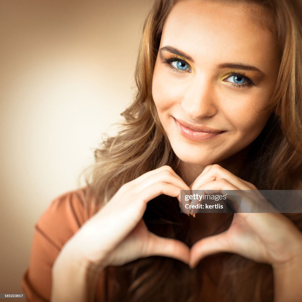 Portrait of a teen girl making a heart shape with her hands