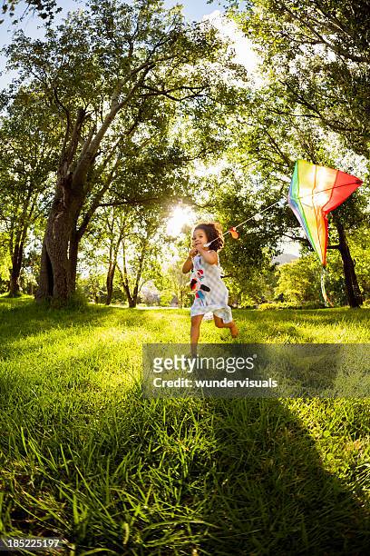 little girl running with a kite in garden - kite flying stock pictures, royalty-free photos & images