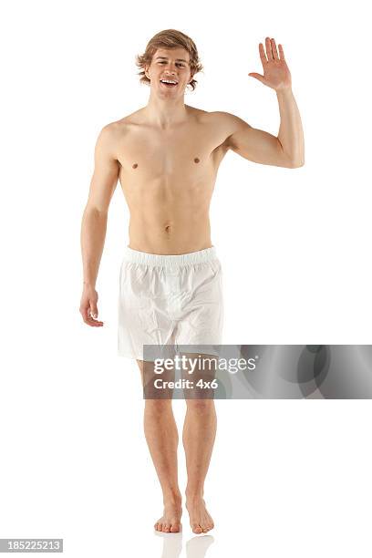 bare chested man walking and waving hand - white shorts stock pictures, royalty-free photos & images