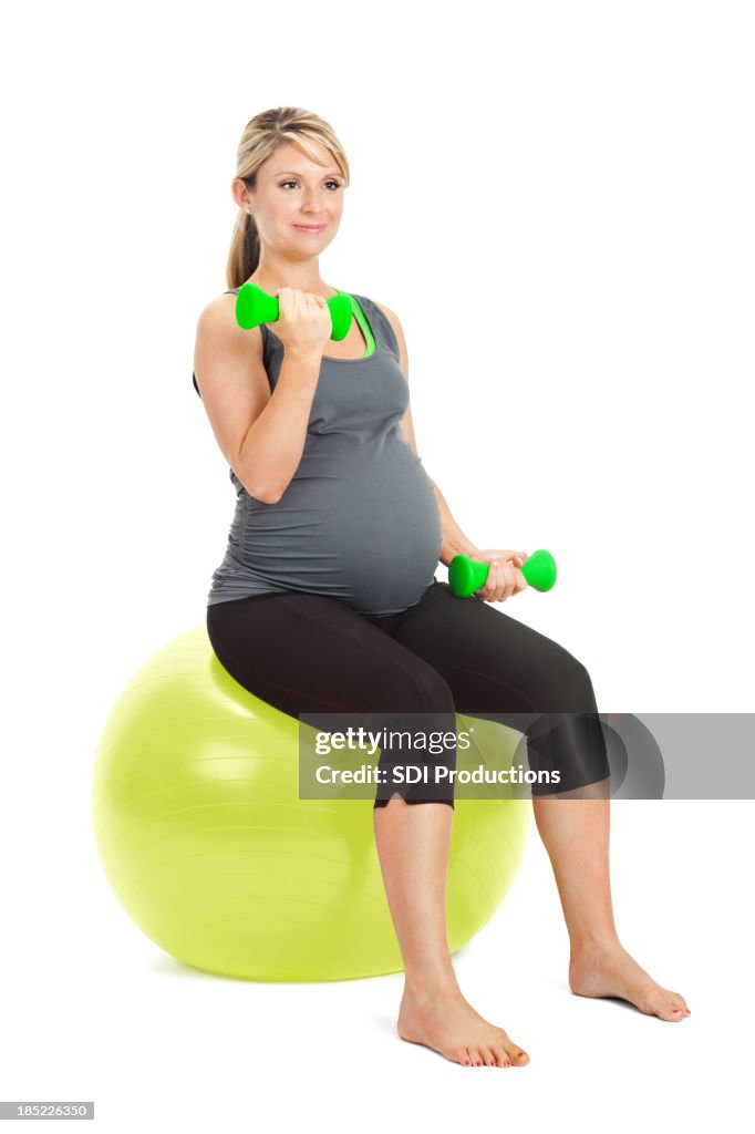 Pregnant woman lifting weights on exercise ball