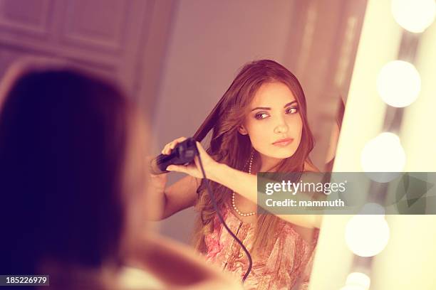 mädchen mit eisstockschießen bügeleisen - lockenstab stock-fotos und bilder