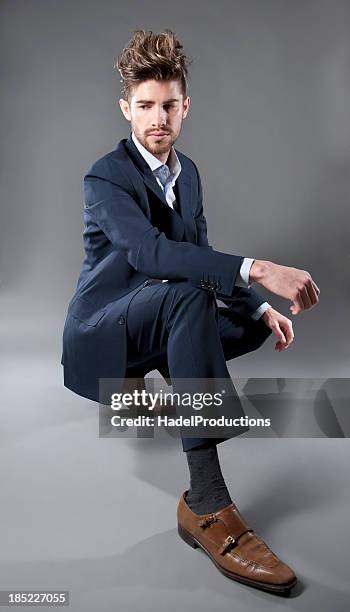 male fashion model on grey background - model crouching stock pictures, royalty-free photos & images