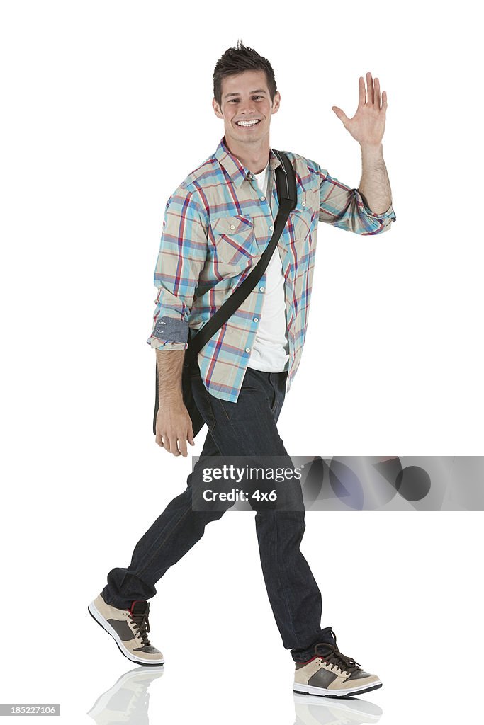 Portrait of a happy man walking and waving his hand