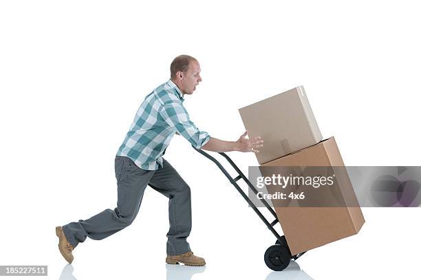 man carrying cardboard boxes in a warehouse - delivery person on white stock pictures, royalty-free photos & images