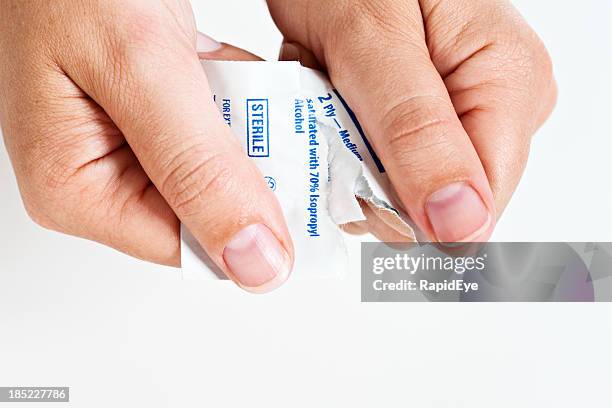 female hands open sterile swab used to disinfect skin - sachet stockfoto's en -beelden