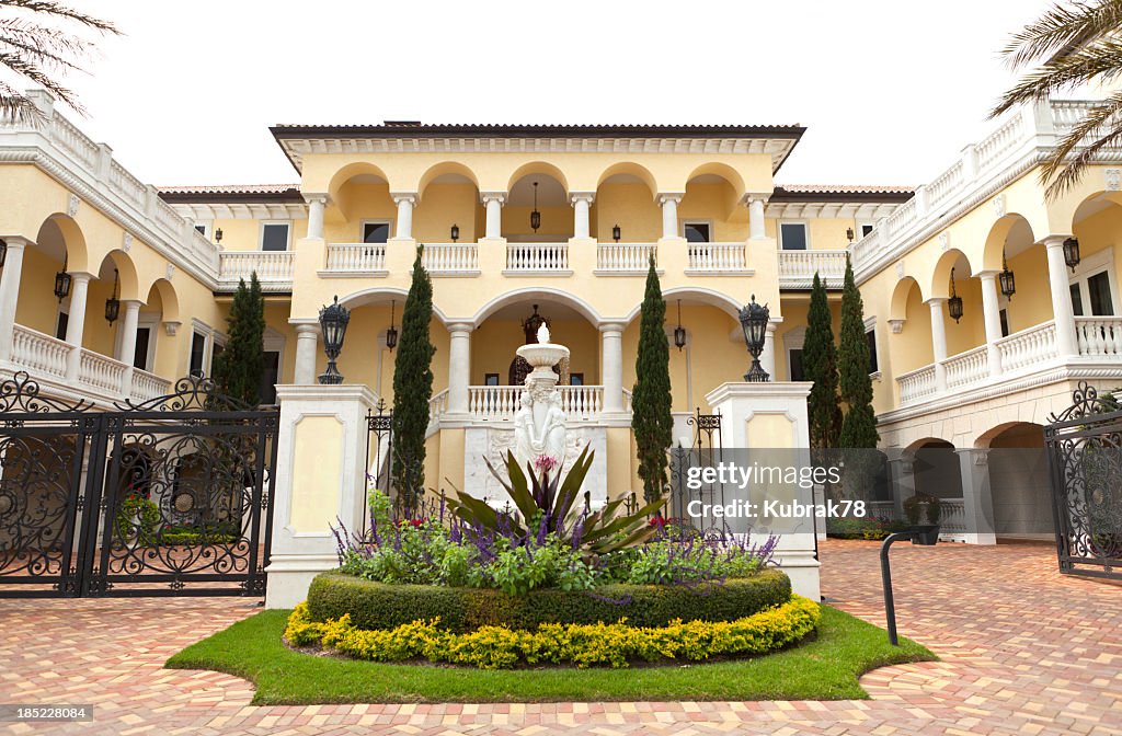 Driveway to luxury two story yellow and White House