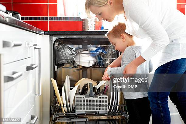 mother and son loading dishwasher - loading dishwasher stock pictures, royalty-free photos & images