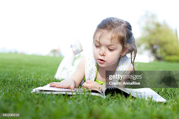 cute little girl reading magazine - nature magazine stock pictures, royalty-free photos & images