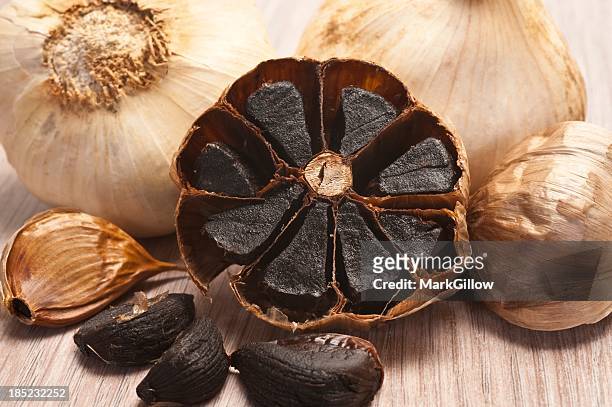 close-up of caramelized flesh of black garlic - zwarte kleur stockfoto's en -beelden