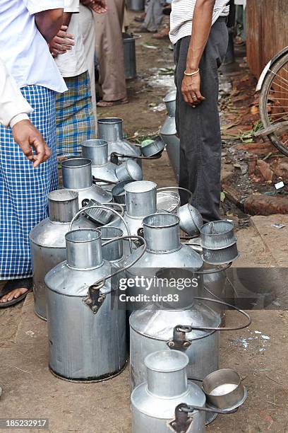 open milk churns lined up on varanasi pavement - butter churn stock pictures, royalty-free photos & images