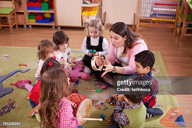 preschoolers and teacher - peuterschool gebouw stockfoto's en -beelden