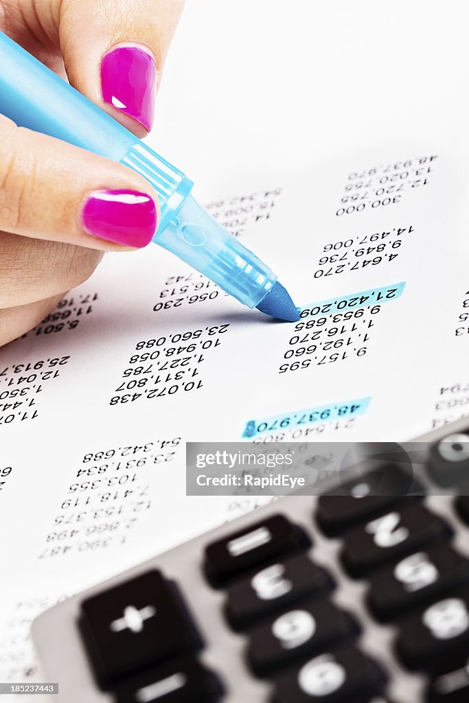 Main féminine les chiffres sur une feuille de calcul dans la zone bleue