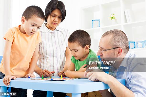 mixed race family playing board game. - game night leisure activity stock pictures, royalty-free photos & images
