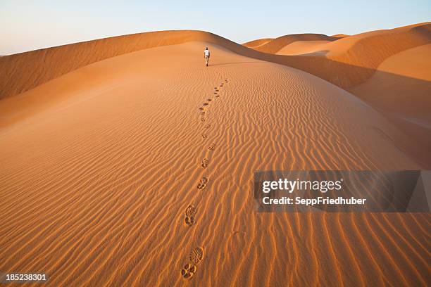 walking in the sand dunes with foot prints - oman stockfoto's en -beelden