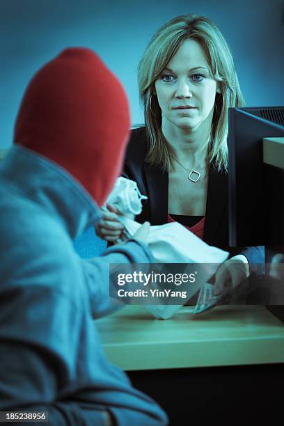 bank robber in action robbing retail banking counter - bank robber stock pictures, royalty-free photos & images