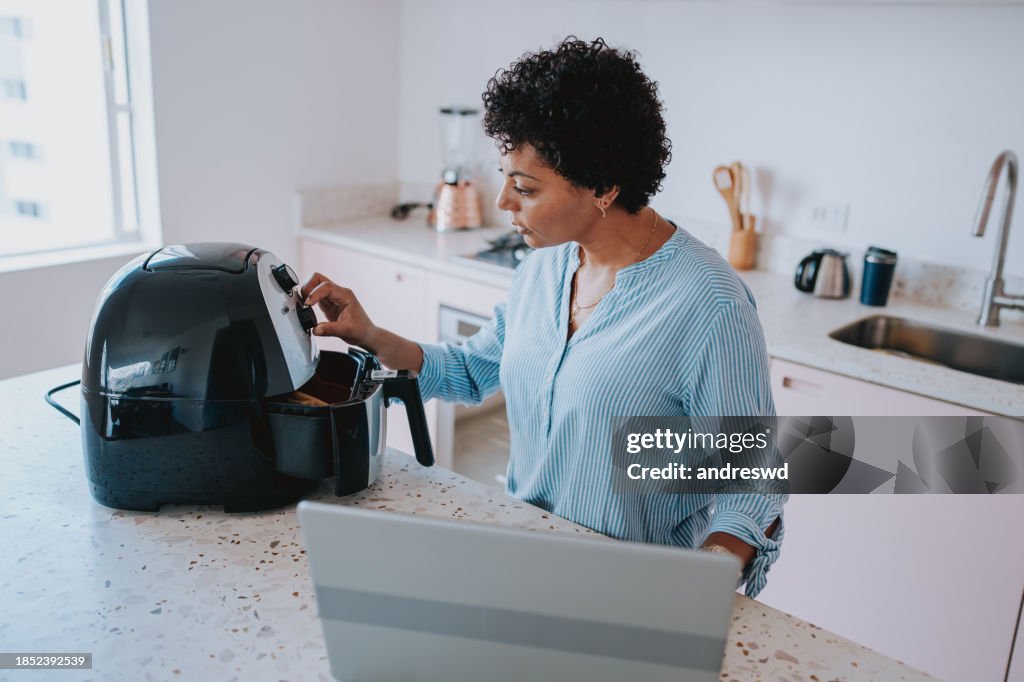 Woman preparing food in oil-free fryer