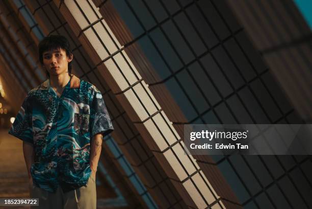 asian chinese young man looking at camera with cool attitude at night at city street - men fashion model stock pictures, royalty-free photos & images